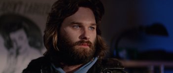 Movie still from “The Thing” (1982), directed by John Carpenter – A person with long hair and a beard; Close Up shot, Low angle