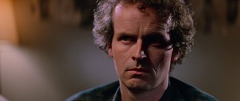 Movie still from “The Thing” (1982), directed by John Carpenter – A person with curly hair; Close Up shot, Low angle