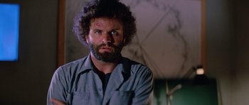 Movie still from “The Thing” (1982), directed by John Carpenter – A man with a beard is looking at the camera; Close Up shot, Low angle