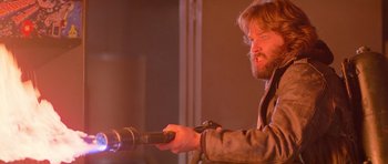 Movie still from “The Thing” (1982), directed by John Carpenter – A man holding a remote control in his hand; Close Up shot, Low angle