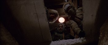 Movie still from “The Thing” (1982), directed by John Carpenter – A group of people wearing winter coats and hats; Medium shot, Low angle