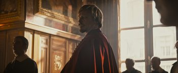 Movie still from “The Three Musketeers - Part I: D'Artagnan” (2023), directed by Martin Bourboulon – A person wearing a cape; Medium shot, Over the shoulder angle