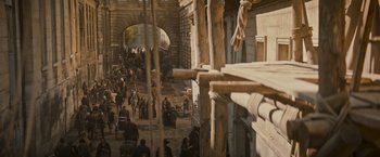 Movie still from “The Three Musketeers - Part I: D'Artagnan” (2023), directed by Martin Bourboulon – A group of people standing on top of a dirt field; Extreme Wide shot, High angle