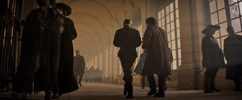 Movie still from “The Three Musketeers - Part I: D'Artagnan” (2023), directed by Martin Bourboulon – A group of people walking down a walkway; Wide shot, Low angle