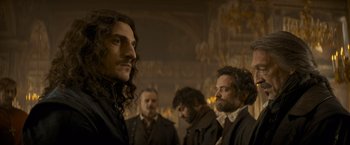 Movie still from “The Three Musketeers - Part I: D'Artagnan” (2023), directed by Martin Bourboulon – A group of men standing next to each other in a room; Medium shot, Low angle