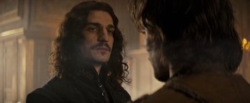 Movie still from “The Three Musketeers - Part I: D'Artagnan” (2023), directed by Martin Bourboulon – A person with long hair looking in a mirror; Close Up shot, Over the shoulder angle