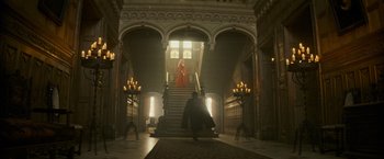 Movie still from “The Three Musketeers - Part I: D'Artagnan” (2023), directed by Martin Bourboulon – A man in a red robe walking down a staircase; Extreme Wide shot, Low angle