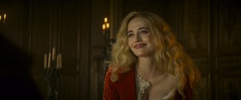 Movie still from “The Three Musketeers - Part I: D'Artagnan” (2023), directed by Martin Bourboulon – A woman with blonde curly hair smiling for the camera; Close Up shot, Over the shoulder angle