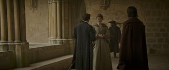 Movie still from “The Three Musketeers - Part I: D'Artagnan” (2023), directed by Martin Bourboulon – Two people are standing in a hallway talking to each other; Wide shot, Over the shoulder angle