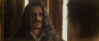 Movie still from “The Three Musketeers - Part I: D'Artagnan” (2023), directed by Martin Bourboulon – A person with long hair; Close Up shot, Over the shoulder angle