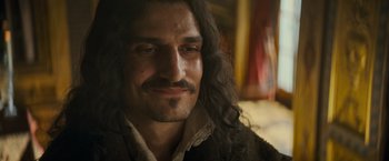 Movie still from “The Three Musketeers - Part I: D'Artagnan” (2023), directed by Martin Bourboulon – A person with long black hair; Close Up shot, Over the shoulder angle