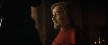Movie still from “The Three Musketeers - Part I: D'Artagnan” (2023), directed by Martin Bourboulon – A person wearing a red shirt; Close Up shot, Over the shoulder angle