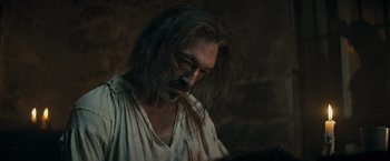 Movie still from “The Three Musketeers - Part I: D'Artagnan” (2023), directed by Martin Bourboulon – A man with long black hair and a mustache; Close Up shot, Over the shoulder angle