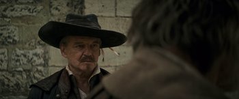 Movie still from “The Three Musketeers - Part I: D'Artagnan” (2023), directed by Martin Bourboulon – An older man wearing a hat looking at a younger man; Close Up shot, Over the shoulder angle