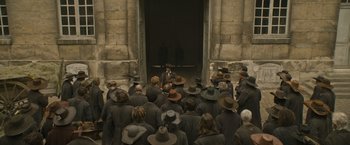 Movie still from “The Three Musketeers - Part I: D'Artagnan” (2023), directed by Martin Bourboulon – A group of people standing in front of a building; Wide shot, High angle