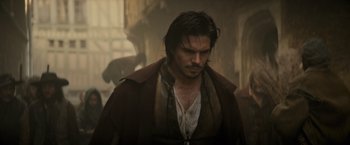 Movie still from “The Three Musketeers - Part I: D'Artagnan” (2023), directed by Martin Bourboulon – A person with a beard; Medium shot, Over the shoulder angle