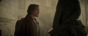 Movie still from “The Three Musketeers - Part I: D'Artagnan” (2023), directed by Martin Bourboulon – A man standing next to another man in a room; Medium shot, Over the shoulder angle