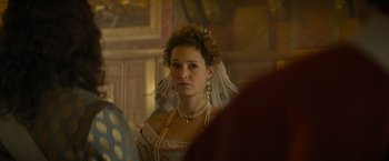 Movie still from “The Three Musketeers - Part I: D'Artagnan” (2023), directed by Martin Bourboulon – A woman wearing a veil and pearls in a room; Close Up shot, Over the shoulder angle