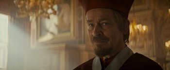 Movie still from “The Three Musketeers - Part I: D'Artagnan” (2023), directed by Martin Bourboulon – A person with a beard wearing a hat; Close Up shot, Over the shoulder angle