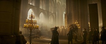 Movie still from “The Three Musketeers - Part I: D'Artagnan” (2023), directed by Martin Bourboulon – A group of people standing inside of a church; Wide shot, Low angle