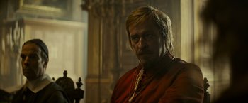 Movie still from “The Three Musketeers - Part I: D'Artagnan” (2023), directed by Martin Bourboulon – A person wearing a red shirt; Medium shot, Over the shoulder angle