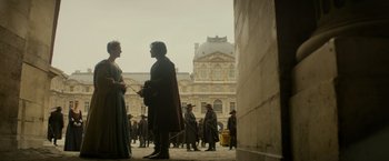 Movie still from “The Three Musketeers - Part I: D'Artagnan” (2023), directed by Martin Bourboulon – A group of people standing in front of a building; Wide shot, Over the shoulder angle