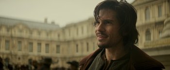 Movie still from “The Three Musketeers - Part I: D'Artagnan” (2023), directed by Martin Bourboulon – A person with long brown hair; Close Up shot, Over the shoulder angle