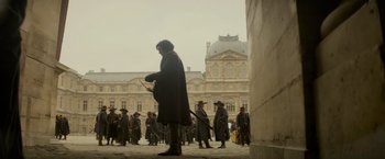 Movie still from “The Three Musketeers - Part I: D'Artagnan” (2023), directed by Martin Bourboulon – A group of people standing in front of a building; Wide shot, Low angle