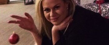 Movie still from “The Tinder Swindler” (2022), directed by Felicity Morris – A beautiful blonde haired woman posing for a picture; Close Up shot, High angle