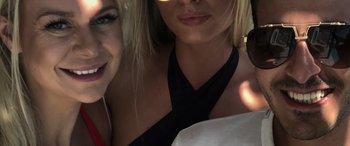 Movie still from “The Tinder Swindler” (2022), directed by Felicity Morris – Two beautiful blonde women posing for a picture; Extreme Close Up shot, High angle