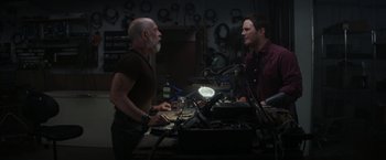 Movie still from “The Tomorrow War” (2021), directed by Chris McKay – Two men are talking in a workshop; Medium shot, Over the shoulder angle