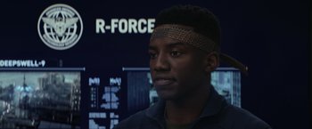 Movie still from “The Tomorrow War” (2021), directed by Chris McKay – A young man wearing a headband in front of a computer screen; Close Up shot, Over the shoulder angle