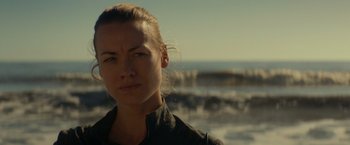 Movie still from “The Tomorrow War” (2021), directed by Chris McKay – A person wearing a black shirt near a body of water; Close Up shot, Over the shoulder angle