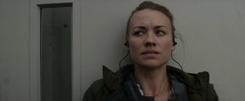 Movie still from “The Tomorrow War” (2021), directed by Chris McKay – A woman wearing headphones looking up into the air; Close Up shot, Over the shoulder angle