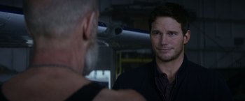 Movie still from “The Tomorrow War” (2021), directed by Chris McKay – A man standing next to another man in front of a plane; Close Up shot, Over the shoulder angle