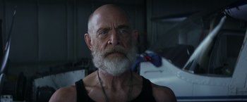 Movie still from “The Tomorrow War” (2021), directed by Chris McKay – An older man with a beard and a necklace; Close Up shot, Low angle