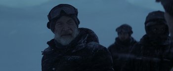 Movie still from “The Tomorrow War” (2021), directed by Chris McKay – An old man with a beard wearing a winter coat and goggles; Close Up shot, Low angle