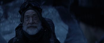 Movie still from “The Tomorrow War” (2021), directed by Chris McKay – An old man with a gray beard wearing a black jacket; Close Up shot, Low angle