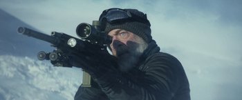 Movie still from “The Tomorrow War” (2021), directed by Chris McKay – A man with a beard wearing a hat and holding a rifle; Medium shot, Over the shoulder angle
