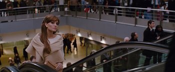 Movie still from “The Tourist” (2010), directed by Florian Henckel von Donnersmarck – A woman riding an escalator in a shopping center; Medium shot, Low angle