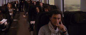 Movie still from “The Tourist” (2010), directed by Florian Henckel von Donnersmarck – A group of people sitting in a row of seats on a train; Close Up shot, Over the shoulder angle