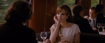 Movie still from “The Tourist” (2010), directed by Florian Henckel von Donnersmarck – A woman sitting at a table with a glass of wine in front of her; Close Up shot, Over the shoulder angle