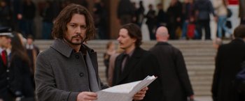 Movie still from “The Tourist” (2010), directed by Florian Henckel von Donnersmarck – A man with long black hair holding a newspaper; Close Up shot, Over the shoulder angle