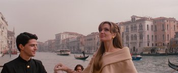 Movie still from “The Tourist” (2010), directed by Florian Henckel von Donnersmarck – A woman standing in front of a body of water; Medium shot, Over the shoulder angle