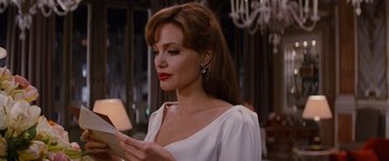 Movie still from “The Tourist” (2010), directed by Florian Henckel von Donnersmarck – A woman in a white dress looking at her cell phone; Close Up shot, Over the shoulder angle