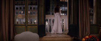 Movie still from “The Tourist” (2010), directed by Florian Henckel von Donnersmarck – A woman in a long white dress standing on a balcony; Wide shot, Over the shoulder angle