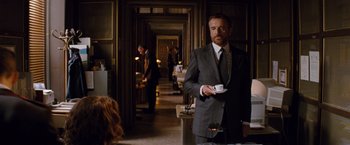 Movie still from “The Tourist” (2010), directed by Florian Henckel von Donnersmarck – A man in a suit and tie holding a coffee cup; Medium shot, Over the shoulder angle