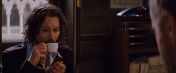 Movie still from “The Tourist” (2010), directed by Florian Henckel von Donnersmarck – A person sitting down with a piece of paper in their hand; Close Up shot, Low angle