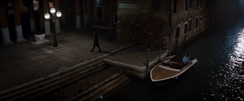 Movie still from “The Tourist” (2010), directed by Florian Henckel von Donnersmarck – A man walking down a street next to a boat; Extreme Wide shot, High angle