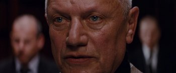 Movie still from “The Tourist” (2010), directed by Florian Henckel von Donnersmarck – An older man with blue eyes stares into the camera; Close Up shot, Low angle